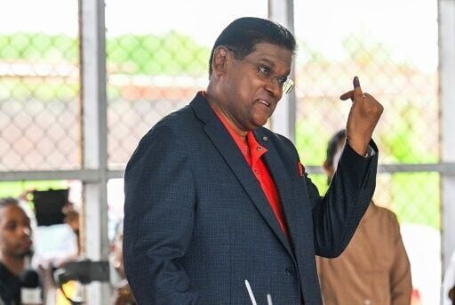 Suriname's President Chan Santokhi shows his inked pinky finger after voting in Paramaribo on May 25, 2025