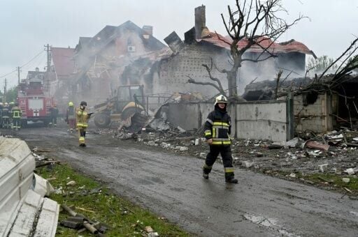 Firefighters operate on a blaze in damaged private houses following Russian strike in Kyiv region on May 25, 2025